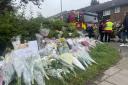 Flowers are left near the scene in Laing Close (Samuel Montgomery/PA)
