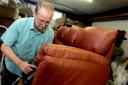 Richard Tebb puts the finishing touches to the upholstery on a leather settee