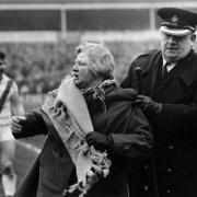 Saints fan Minnie Cotton being escorted from the pitch during the 1966 Challenge Cup semi-final Pic: RFL Archives