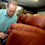 Richard Tebb puts the finishing touches to the upholstery on a leather settee
