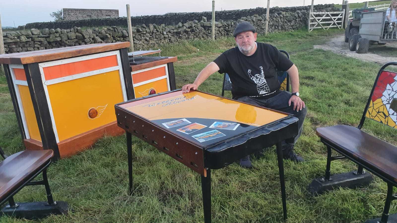 Johnny and his picnic table created from a panel of the bus by Retro Chimps