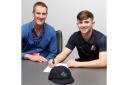 Matthew Hurst, right, signs his first professional contract with Lancashire as Performance Director Mark Chilton looks on