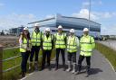 Councillor Kate Groucutt, Council Leader Councillor David Baines and officials from the developers at Omega West outside one of the new units being built