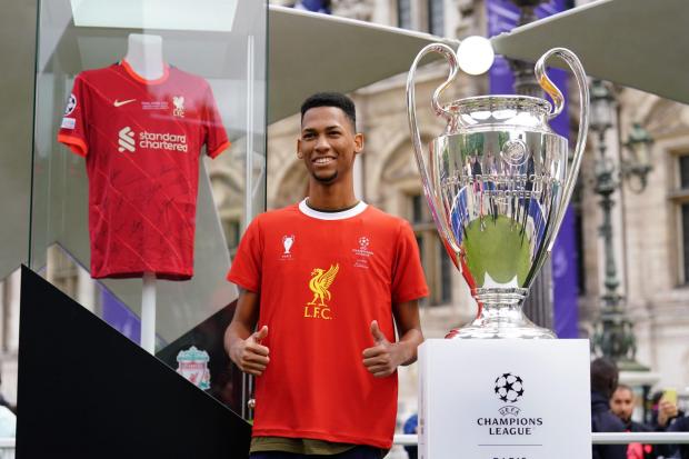 St Helens Star: A Liverpool fan poses next to the Uefa Champions League trophy (Adam Davy/PA)
