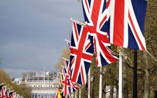 Union flags hang from the street furniture outside Buckingham Palace on the Mall, London, ahead of the coronation of King Charles III